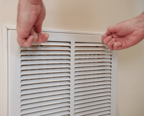 HVAC technician installing residential grille