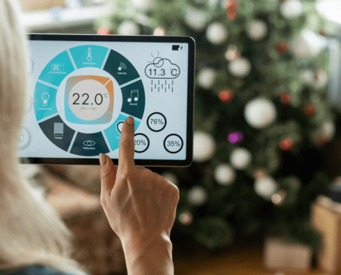 Homeowner using smart thermostat during holiday season