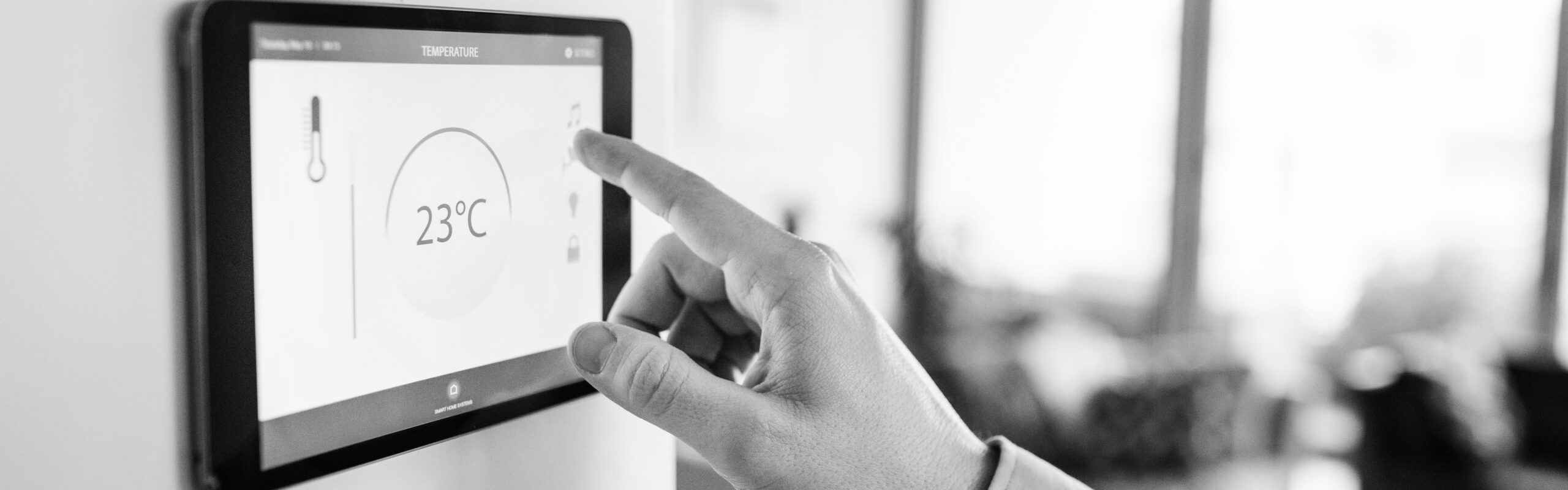 Man pointing at smart home thermostat